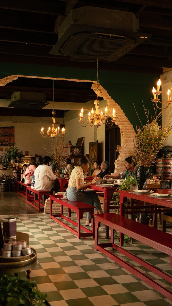 The Toh-Daeng red-table dining room at Baan Ar-Jor, long red tables under heritage chandeliers