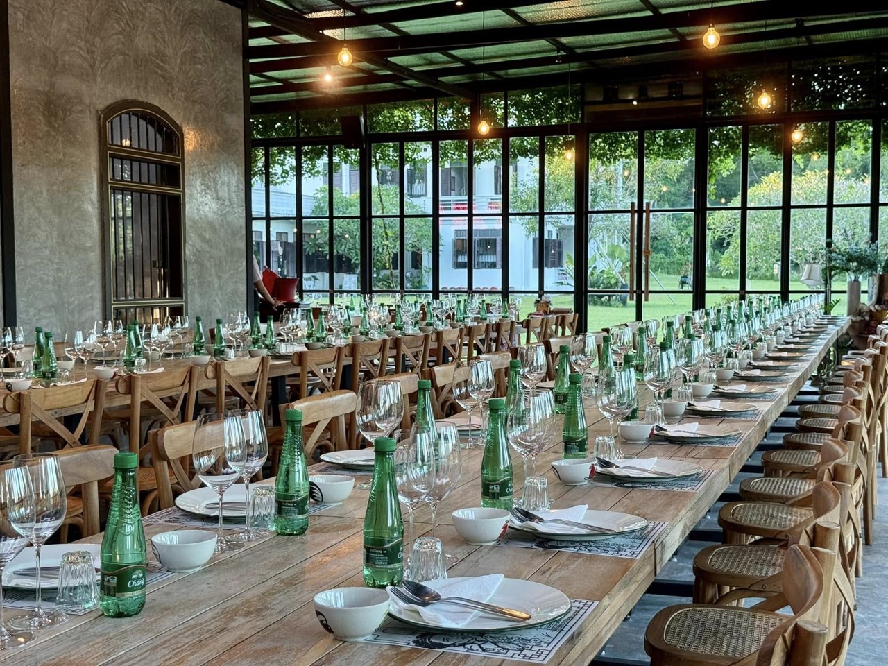 Wo-Ai-Ni glass house set with a long banquet table for a private dinner
